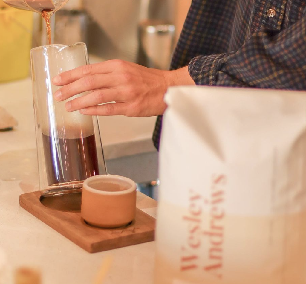 Copan Trade founders Sheri and Walter Dunaway among bags of green coffee at their warehouse